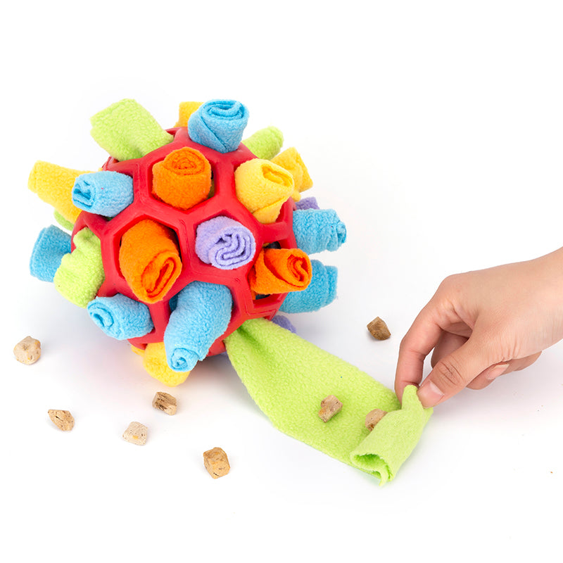 Dog nosing treats out of fleece snuffle ball